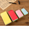 Collection d'enveloppes en papier colorées jaune, rose et bleu clair sur une surface en bois avec du papier