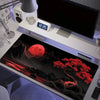 A large silicone gaming mouse pad featuring a dramatic red moon landscape and dark terrain.