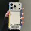 Una mano sostiene una funda de silicona transparente para teléfono anti-caídas con la palabra COLOMBIA impresa en la parte po