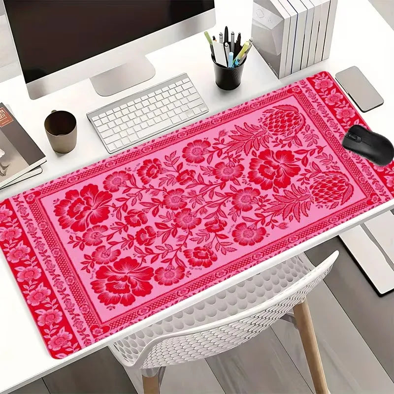 A vibrant pink vintage Persian rug gaming mouse pad with a non-slip rubber base placed on a white desk.