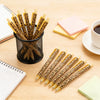 A collection of leopard print retractable ballpoint pens in black ink arranged on a wooden surface with notebooks.