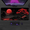 A large silicone gaming mouse pad is displayed on a wooden desk, featuring a dark background and glowing red elements.