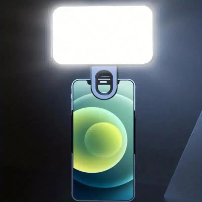 A portable rechargeable mini selfie light illuminates a smartphone with a bright white light.