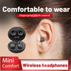 Primer plano de auriculares inalámbricos mini con control táctil por huella dactilar cerca de una oreja humana.