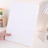 A white A4 document and photo storage file box being held by a hand on a light surface.