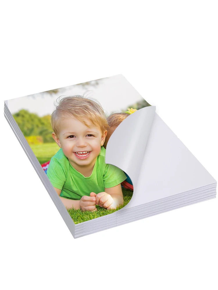 A photo of a smiling toddler outdoors is shown on a sheet of glossy self-adhesive photo paper.