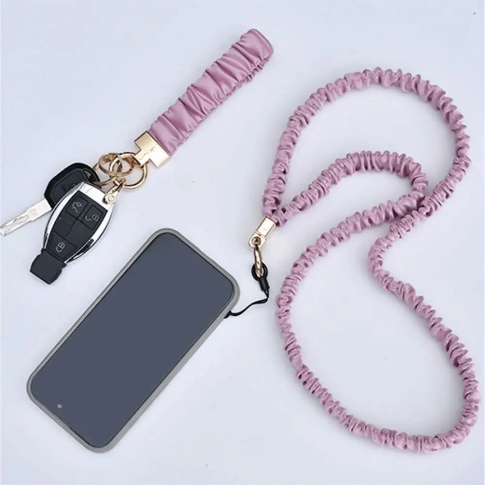 A pink stretchy breakaway lanyard with a retractable reel and an ID badge holder is shown next to a smartphone.