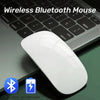 A white wireless Bluetooth mouse resting on a black laptop keyboard.