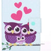 A light blue folio tablet case featuring a design of three purple owls and pink hearts.