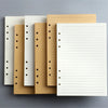 Una pila de recambios de cuadernos de hojas sueltas de varios colores, tonos blancos, beige y amarillos.