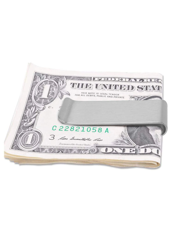 A rolled US one dollar bill is shown with a stainless steel money clip placed on top.