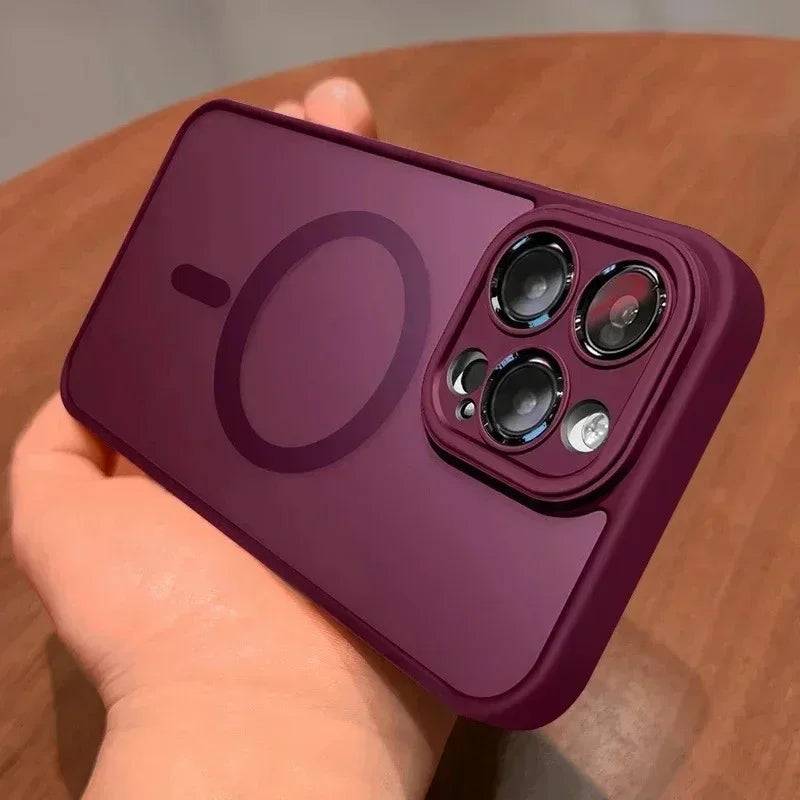 A hand holds a deep purple magnetic wireless charging lens protector case for an iPhone, showing the camera module.