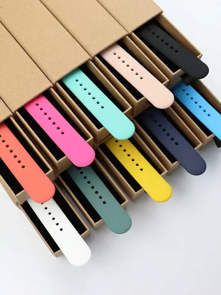 A box filled with various colored silicone sport bands for an Apple Watch, arranged in rows.