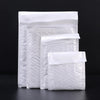 A stack of white self-sealing pearl film bubble shipping bags.