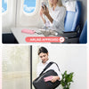 A woman uses a compact power bank with a built-in AC plug and dual cables on an airplane seat.