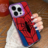 A hand holds a phone case featuring a red spiderweb design on a dark background.