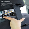 A hand is pressing a black flexible car headrest mount designed for holding tablets and phones onto a car seat.