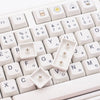 Nahaufnahme weißer PBT-Tastenkappen für eine mechanische Tastatur mit verschiedenen Zeichen und Symbolen