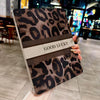 A leopard print protective case for an iPad, featuring a brown and black pattern with the text GOOD LUCKY.