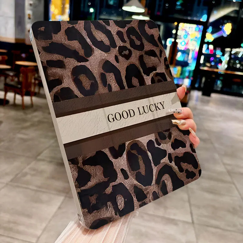 A leopard print protective case for an iPad, featuring a brown and black pattern with the text GOOD LUCKY.