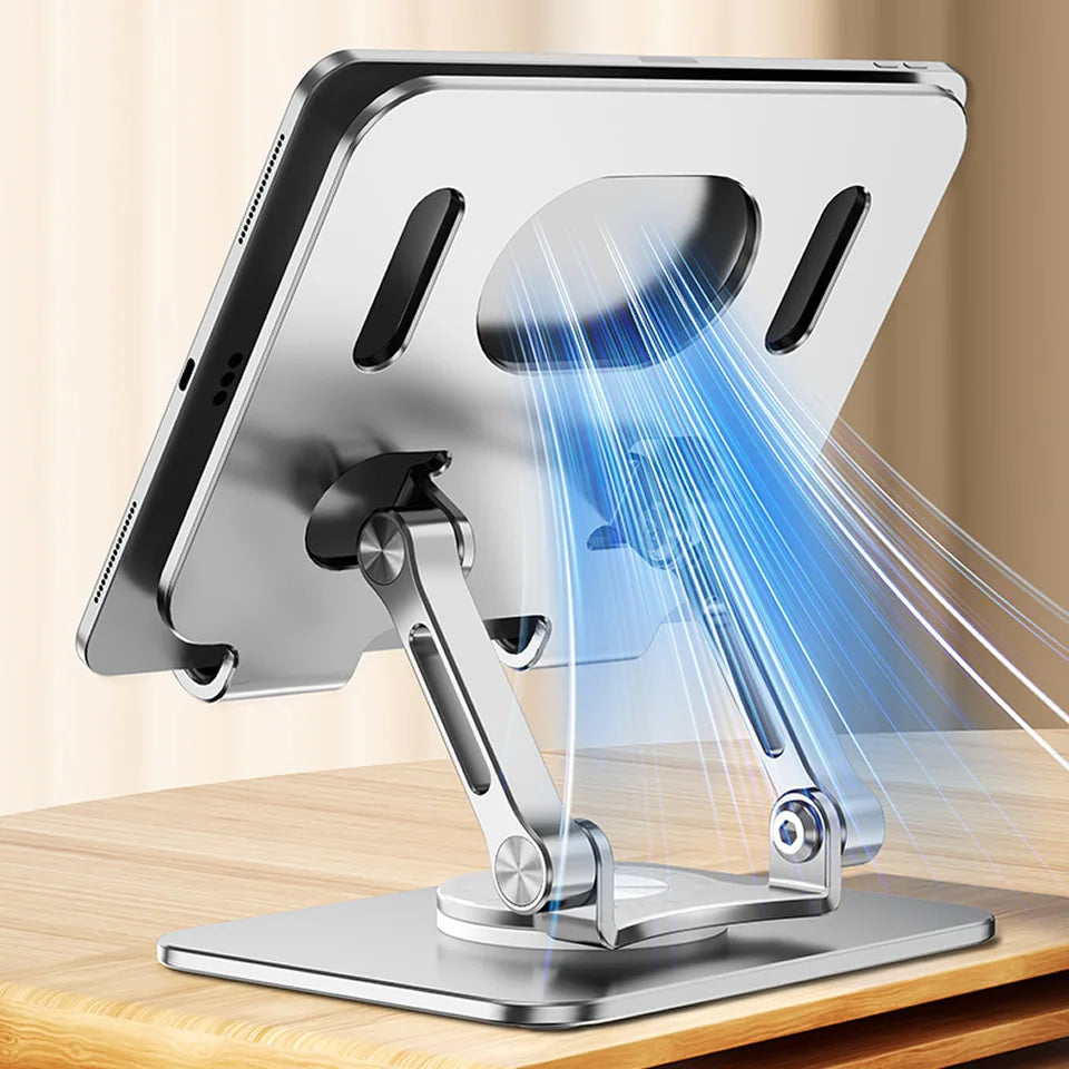 A silver tablet stand with a rotating mechanism is shown illuminating a device on a wooden surface.