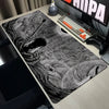 A large black and white anime design mouse pad featuring a detailed Berserk theme on a gaming desk.
