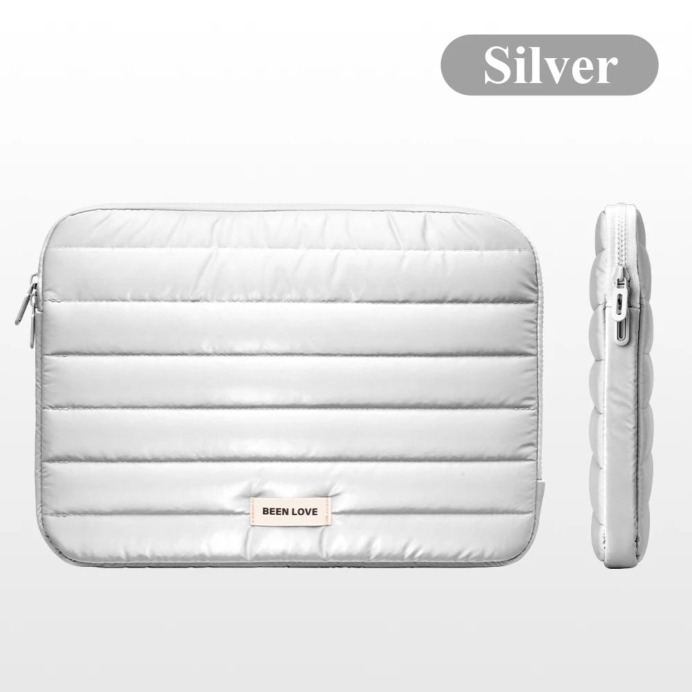 Silver padded laptop sleeve featuring a zipper closure and a Been Love logo.