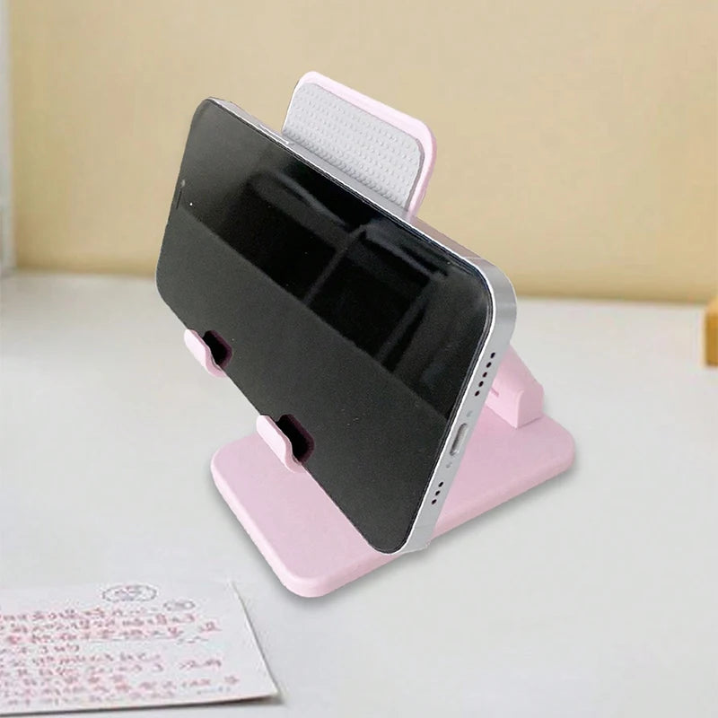 A pink adjustable desktop phone stand holding a black smartphone.