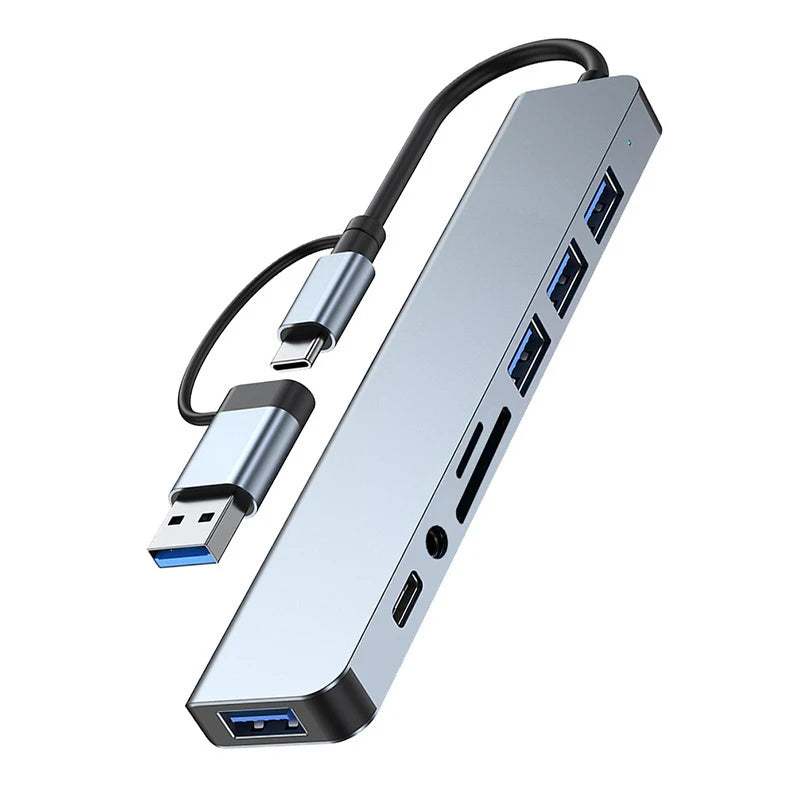 A silver multi-port USB-C hub adapter with multiple ports and an audio jack.