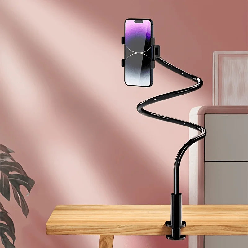A black adjustable phone stand holding a smartphone in a vertical position on a wooden desk.