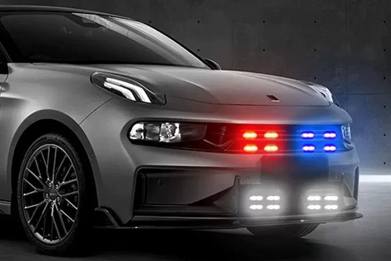 A silver Porsche sports car with red and blue LED lights illuminated on the front grille and bumper.