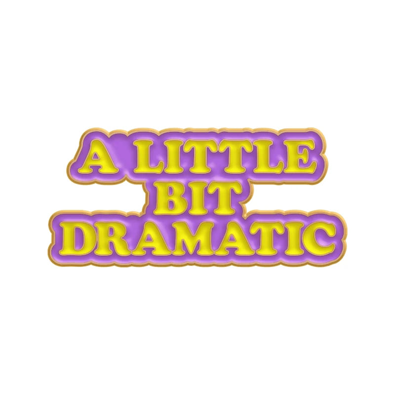 A sarcastic enamel pin featuring the text A LITTLE BIT DRAMATIC in yellow and purple lettering.