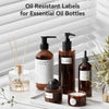 Oil resistant labels for essential oil bottles displayed on a white wooden surface with bamboo sticks and greenery