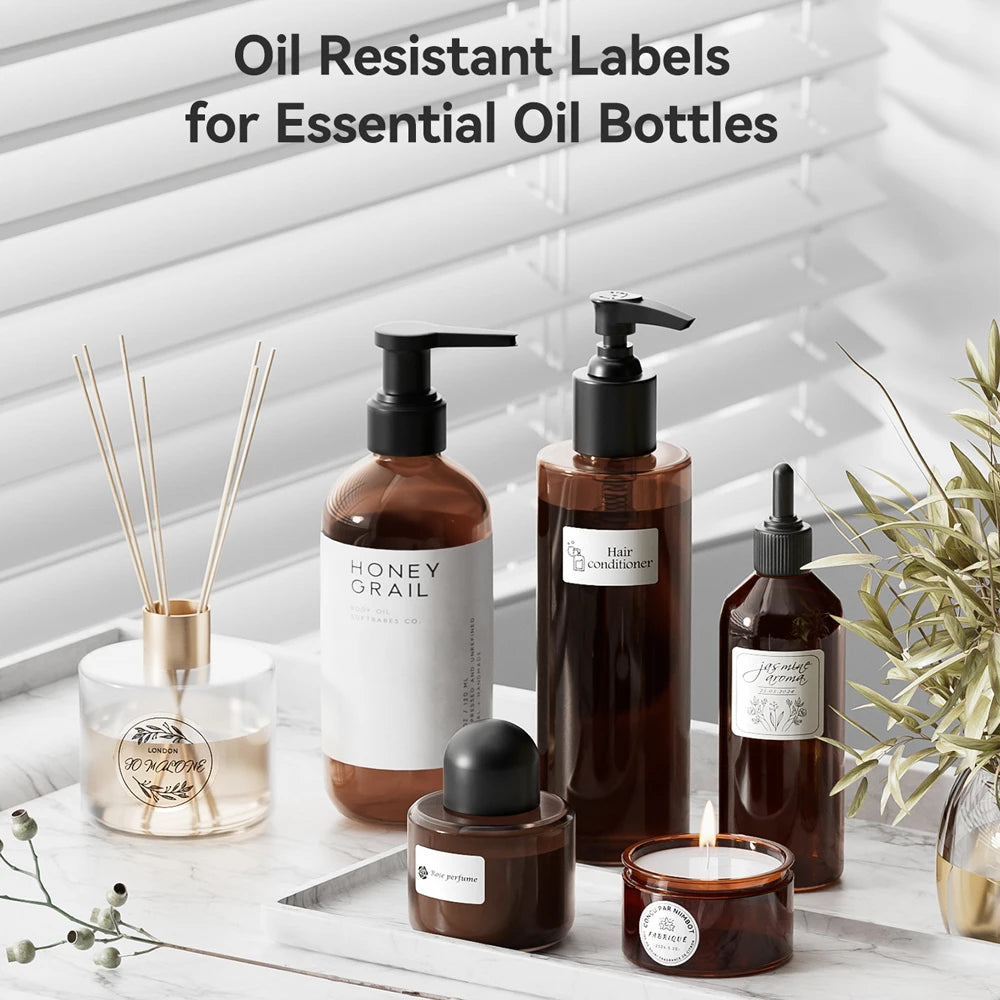 Oil resistant labels for essential oil bottles displayed on a white wooden surface with natural elements.