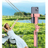 A woman taking a photo outdoors using a pink 360° rotation selfie stick with a smartphone.