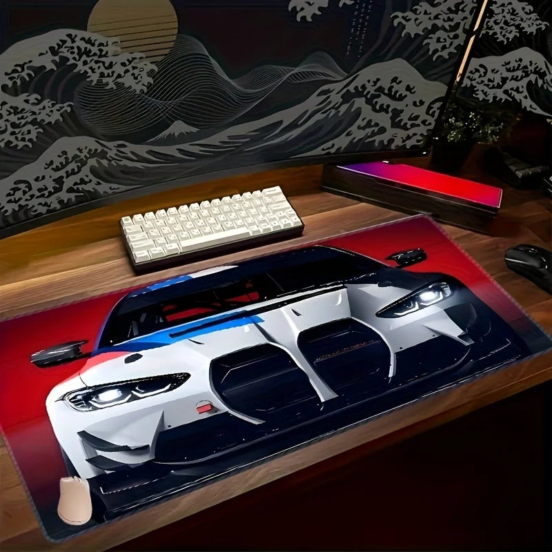 A large non-slip gaming mouse pad featuring a detailed racing car design on a wooden desk.