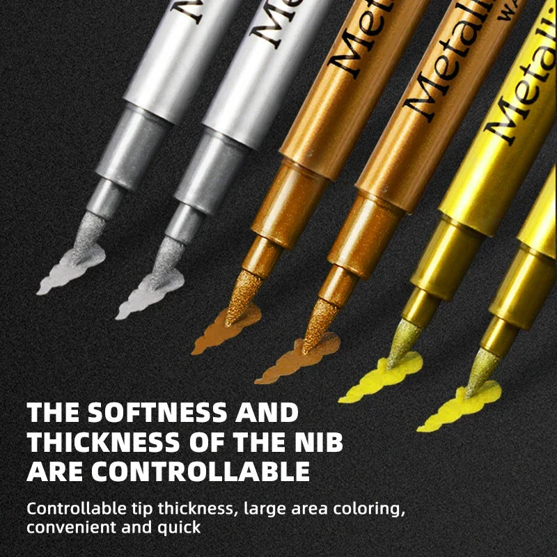 A close-up view of several metallic brush marker pens showing various gold and silver tips.