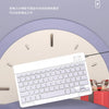 A white 10-inch Bluetooth keyboard and mouse combo is displayed on a purple surface with gift boxes in the background.