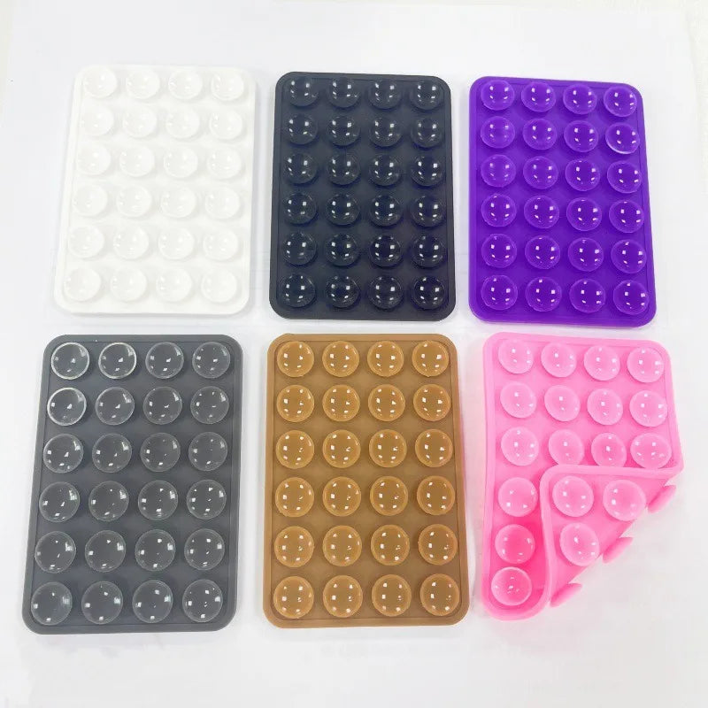 A collection of nine silicone suction cup mounts in various colors including white, black, purple, and pink.
