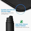 Close-up of a black mouse pad showing durable stitched edges and high elastic natural rubber material for comfort
