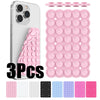 Three silicone suction cup phone holders in various colors and sizes displayed next to a white smartphone.