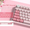 A close-up of a pink mechanical keyboard featuring double shot PBT keycaps and RGB lighting.