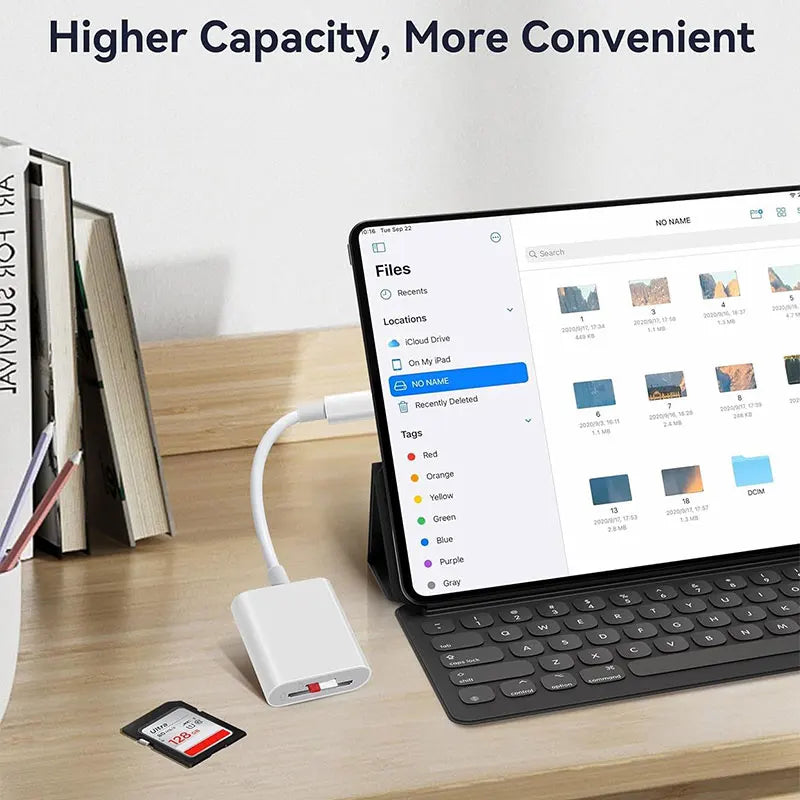 حاسوب محمول يعرض واجهة لإدارة الملفات بجانب قارئ بطاقة USB-C أبيض وكتب على مكتب خشبي.