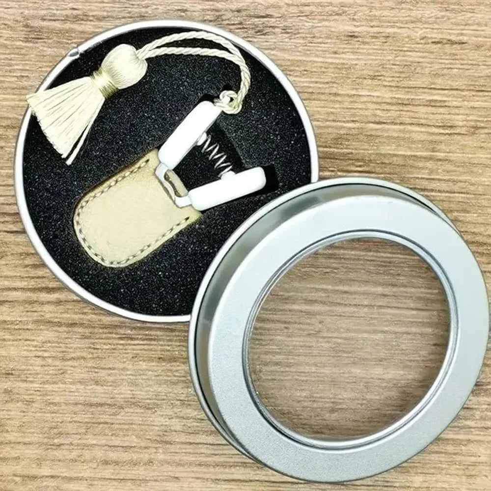 مقص خياطة صغير ذو طرف مستقيم بدقة، بغلاف جلدي ذهبي وخاتم فضي.