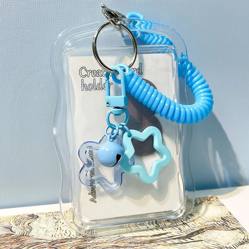 A clear card holder with a light blue beaded keychain featuring a light blue heart shape.