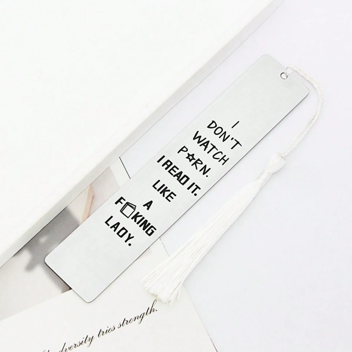 A white silver stainless steel bookmark with a white tassel attached to a card.