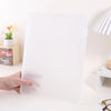 A white A4 document and photo storage file box is being held by a hand on a white surface.