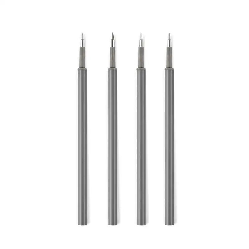 A set of four precision utility knives with sharp blades standing upright.