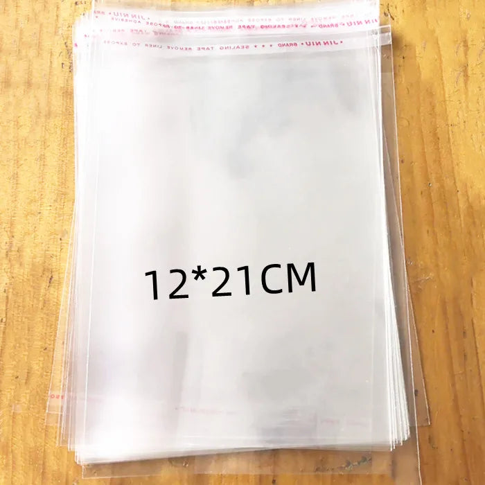 A stack of clear self-sealing plastic bags for jewelry, candy, and gifts is shown on a wooden surface.
