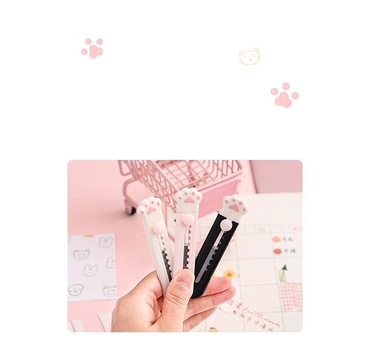 A hand holds a portable pet claw tool knife for crafting and decoration, showing the pink and black tools.